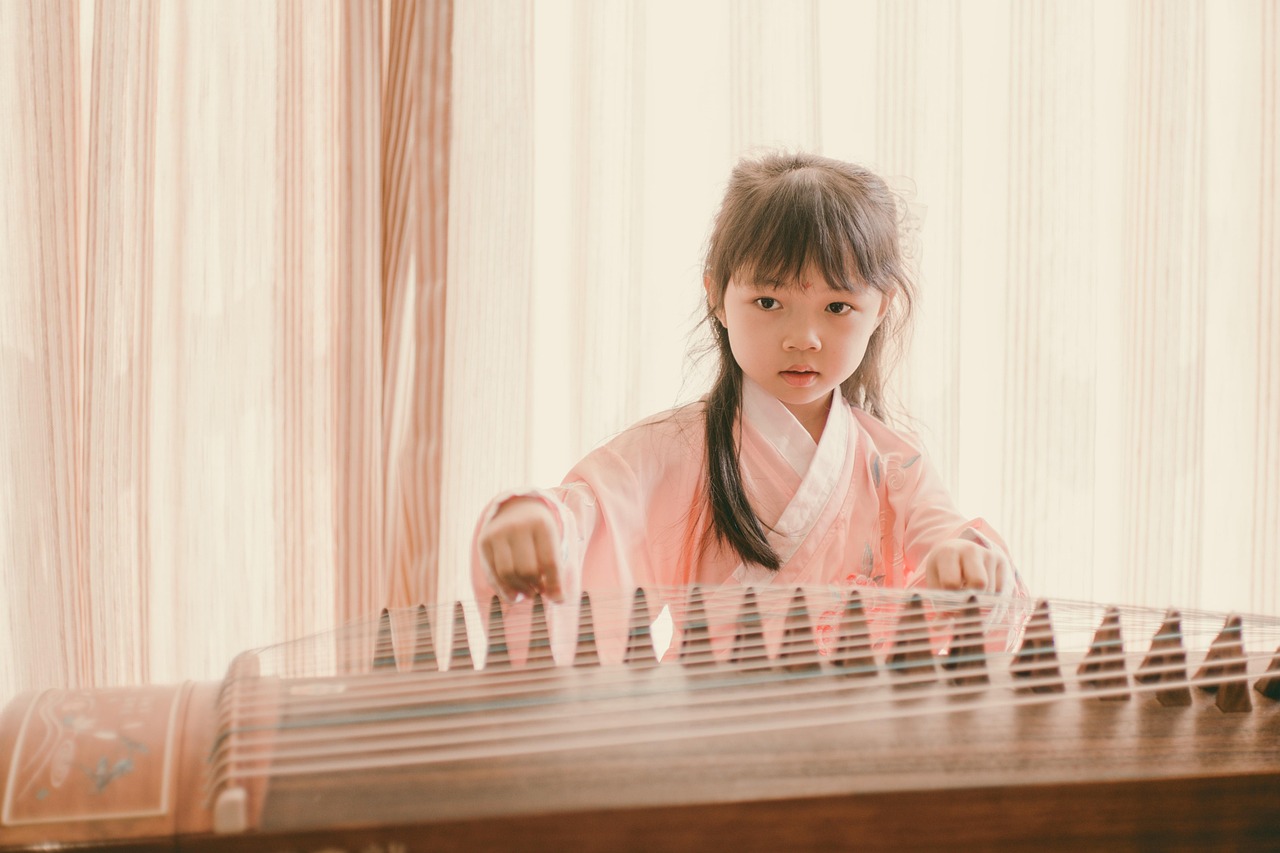 Chinese guzheng zither girl playing traditional instrument